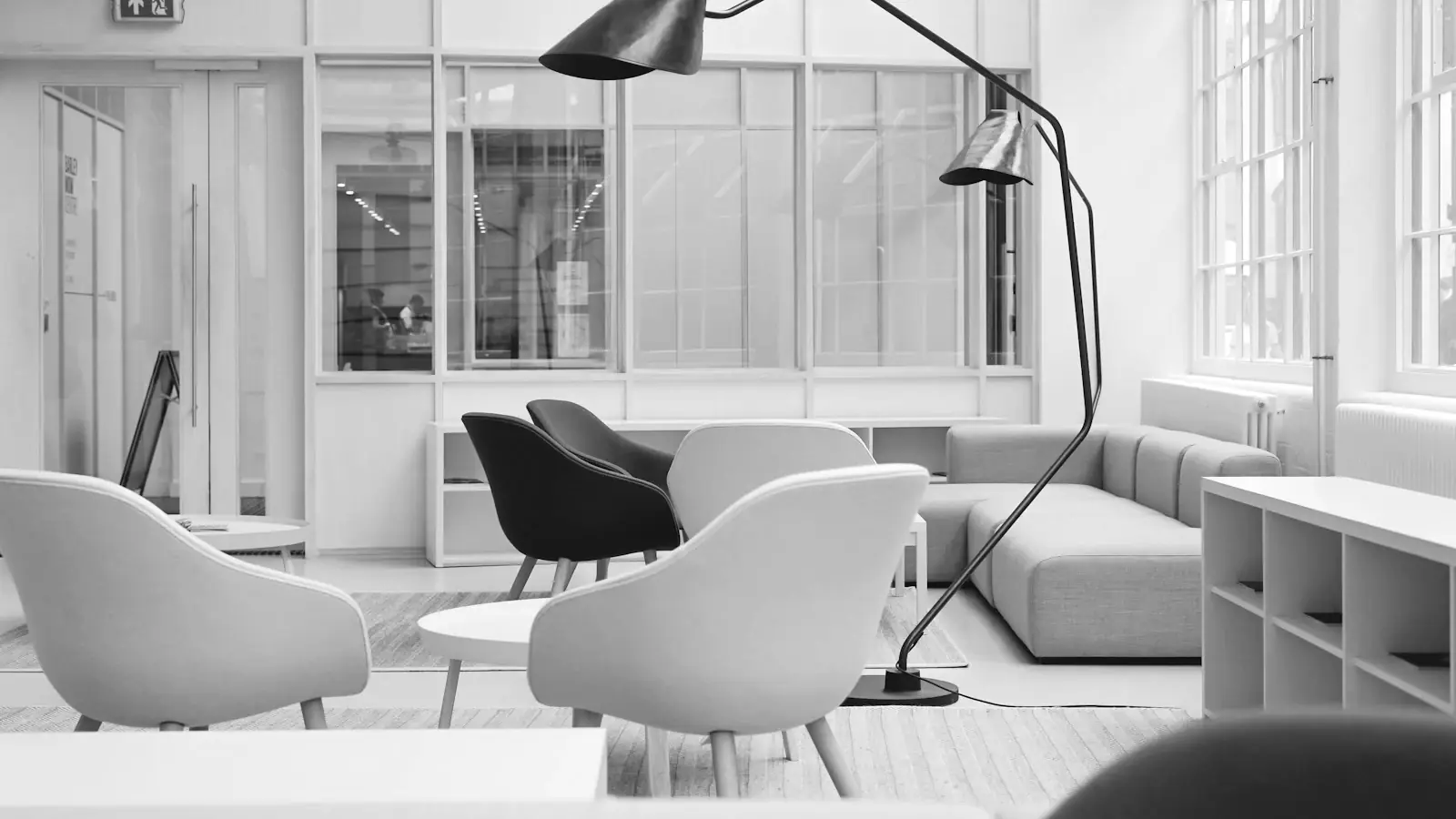 Espacio de oficina luminoso con asientos alrededor de una mesa baja y una lámpara de pie